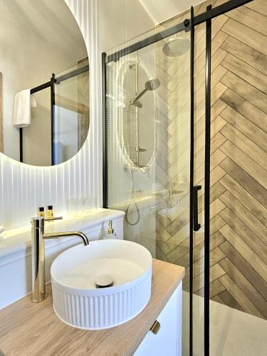 a bathroom with a white sink and a shower at ROOSEVELTA RESIDENCE Apartments - przy OFF Piotrkowska in Łódź