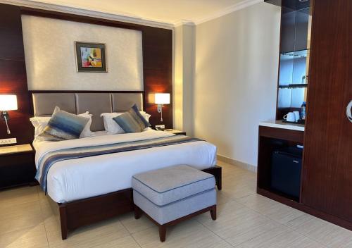 a hotel room with a large bed and a chair at Grand Palace Hotel Lusaka in Lusaka