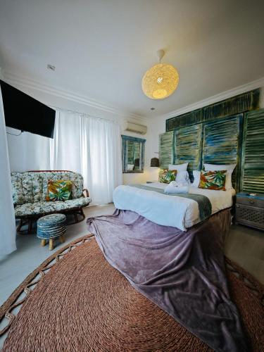 a bedroom with a large bed and a couch at Beachwood Camps Bay in Cape Town