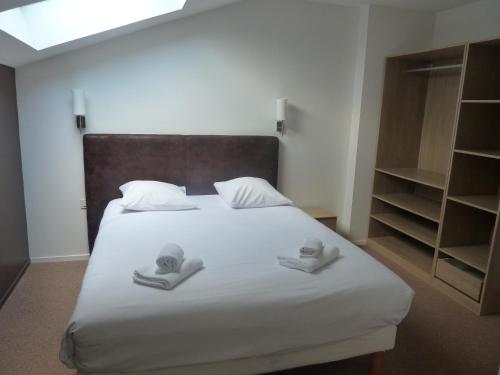 a bedroom with a bed with two towels on it at Hotel Loreak in Bayonne