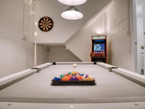 a pool table with a pile of balls on it at London Fulham - hot tub, parking, games & arcade in London