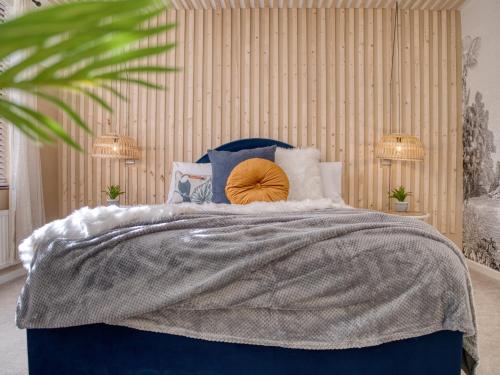 a bed with a blue comforter and pillows at London Fulham - hot tub, parking, games & arcade in London
