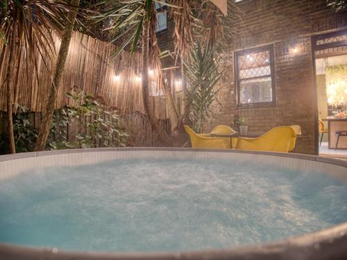 a hot tub in a room with plants and chairs at London Fulham - hot tub, parking, games & arcade in London