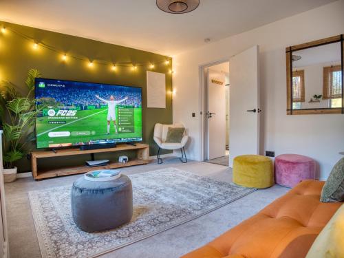 a living room with a large tv and a couch at London Fulham - hot tub, parking, games & arcade in London