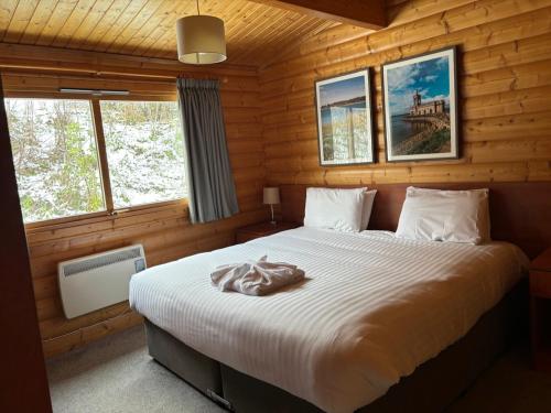 a bedroom with a bed in a log cabin at Greetham Valley in Greetham