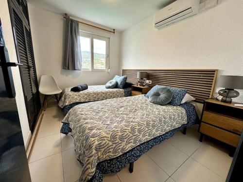 ein Hotelzimmer mit zwei Betten und einem Fenster in der Unterkunft Luxury 2-Bed Marina Apartment in Alcossebre