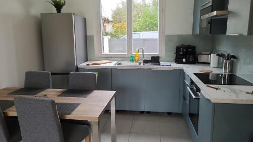 une cuisine avec un évier et une table avec des chaises dans l'établissement Green Escape proxi Bordeaux, à Cenon