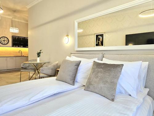 a bedroom with a bed with white sheets and pillows at ROOSEVELTA RESIDENCE Apartments - przy OFF Piotrkowska in Łódź
