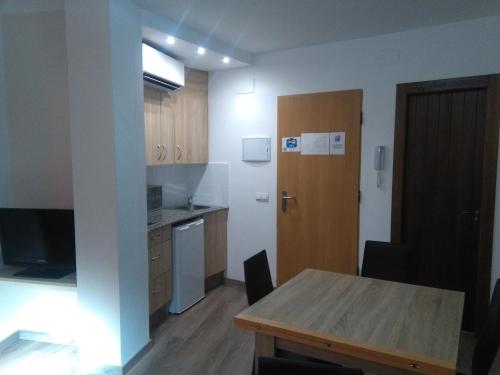 a kitchen with a wooden table and a wooden door at Apartamento Plazuela in Teruel