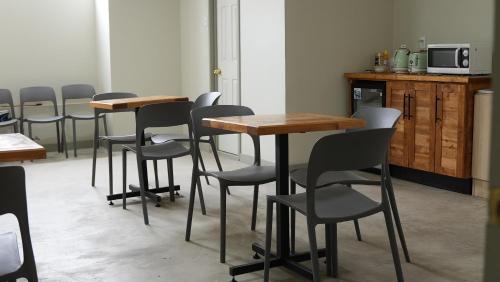 a row of tables and chairs in a room at Alternativo Hostales in Caldera