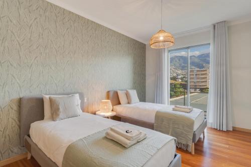 une chambre d'hôtel avec deux lits et une fenêtre dans l'établissement Barreiros Residence I, à Funchal