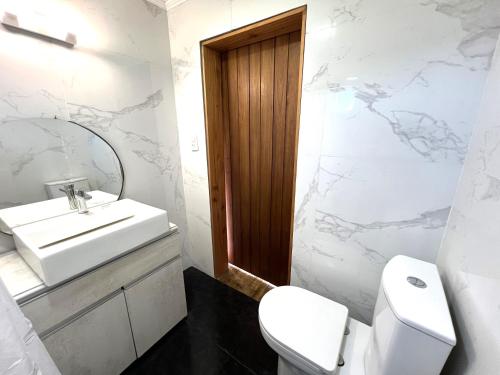 a bathroom with a sink and a toilet and a mirror at Alquiler Mar del Plata Casa en Acantilados in Mar del Plata