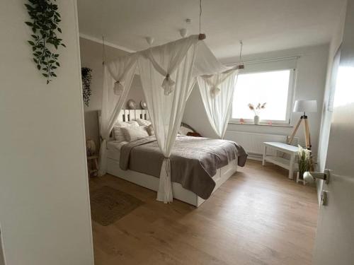 a bedroom with a canopy bed and a window at Weser-City-Panorama 2Zi 9OG 5P Mitte in Bremerhaven