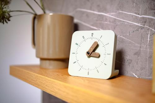 a clock sitting on top of a wooden shelf at MOLO LIPNO RESIDENCE in Lipno nad Vltavou