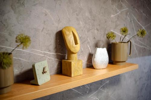 a shelf with vases and a wooden statue on it at MOLO LIPNO RESIDENCE in Lipno nad Vltavou