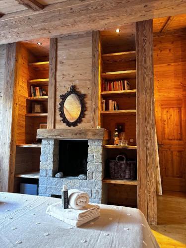 a room with a stone fireplace in a log cabin at Cozy Suite Sils in Sils Maria
