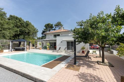 une piscine devant une maison dans l'établissement Location Villa Mimizan 10 pers, à Mimizan-Plage