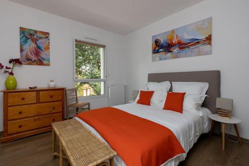 - une chambre avec un lit doté d'une couverture orange et d'une commode dans l'établissement Location Villa Mimizan 10 pers, à Mimizan-Plage