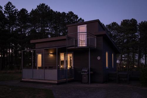 a small black house with a balcony on it at Feddet Strand Resort in Faxe