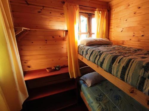 a bedroom with a bed in a log cabin at Observatorio Ampimpa in Amaicha del Valle