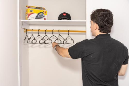 a man reaching for a rack in a refrigerator at Home Sweet Home in Pitalito