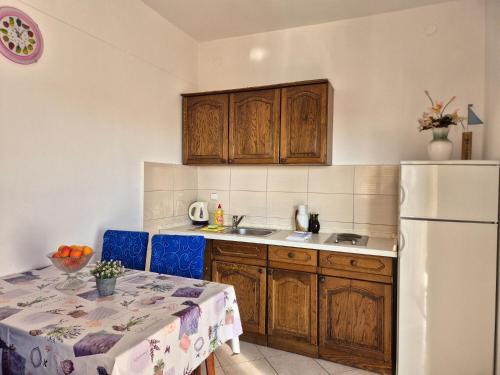 eine Küche mit einem Tisch und einem weißen Kühlschrank in der Unterkunft Apartments Josi in Grebaštica