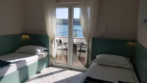 sypialnia z 2 łóżkami i balkonem z widokiem w obiekcie Apartments Jope w mieście Stara Novalja