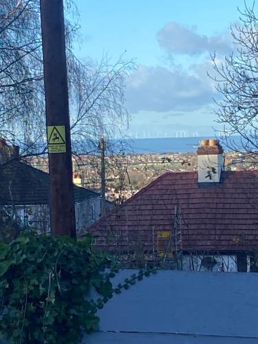 a pole with a sign on it next to a house at Bright cozy rooms in Meliden in Meliden