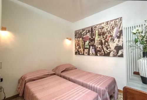 Dos camas en una habitación con un cuadro en la pared. en Vivi Venezia, en Venecia