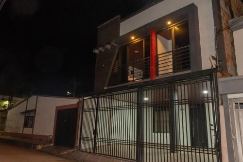 a white house with a balcony at night at Home Sweet Home in Pitalito