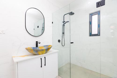 a bathroom with a sink and a shower at Glenelg North House, 3QBed, 2KSBed, 2Bth, 5TV in Glenelg