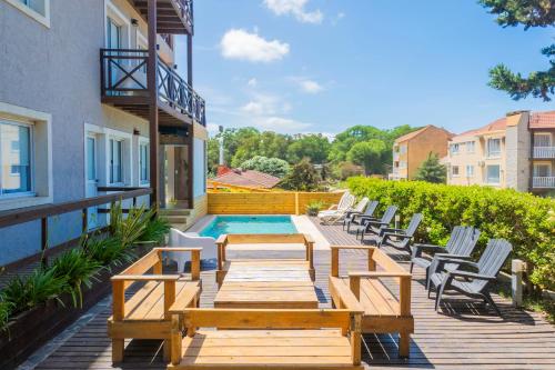 a patio with wooden chairs and a swimming pool at Departamentos NIZA 313 in Ostende