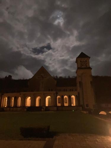 a large building with a clock tower at night at L'aire des oiseaux in Muno