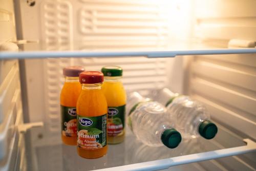 a refrigerator filled with bottles of juice and water at Home Joséphine - CASERTA in Caserta