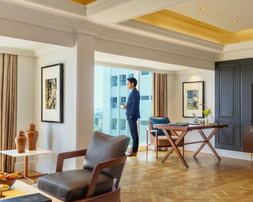 a woman standing in a living room looking out the window at Taj MG Road Bengaluru in Bengaluru