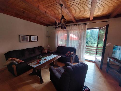 Una sala de estar con dos sofás y una mesa. en Planinska kuća Mali raj, en Jahorina