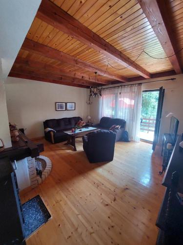 una sala de estar con un sofá y una mesa en Planinska kuća Mali raj, en Jahorina