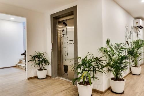 a room with potted plants in front of a door at Super Townhouse Gandhi Hall in Indore