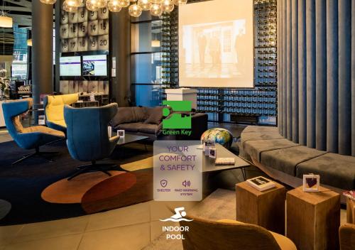 a lobby with a couch and chairs and a presentation at Mercure Kyiv Congress in Kyiv