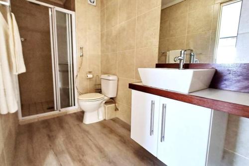 a bathroom with a sink and a toilet and a shower at 1 Anchor Bay in Cape Town