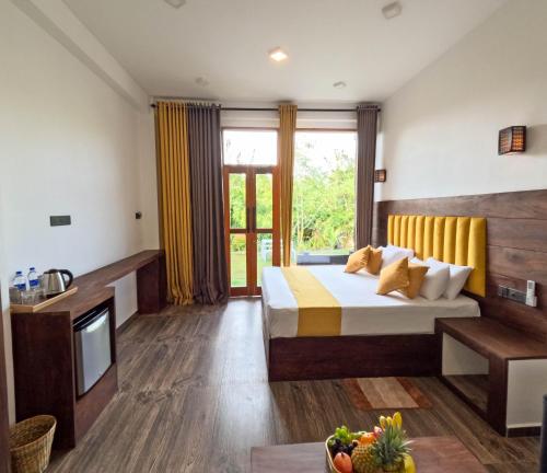 a hotel room with a bed and a tv at Chabee N Jay Villa Madiha Beach in Matara