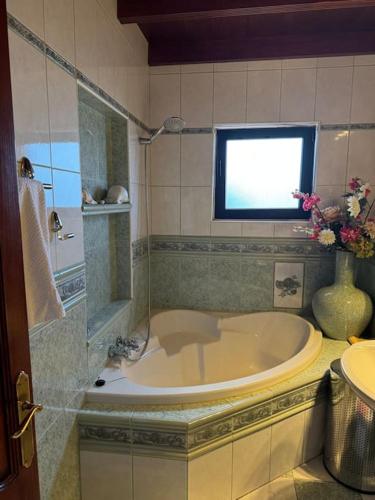 a bathroom with a tub and a window and a sink at Castillo Lanzarote Villa Antonia in Tías