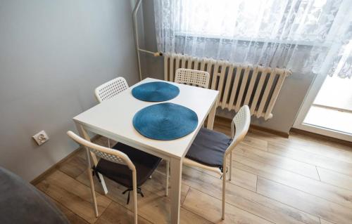 a dining room table with two blue cushions on it at Apartament Okrężna in Toruń