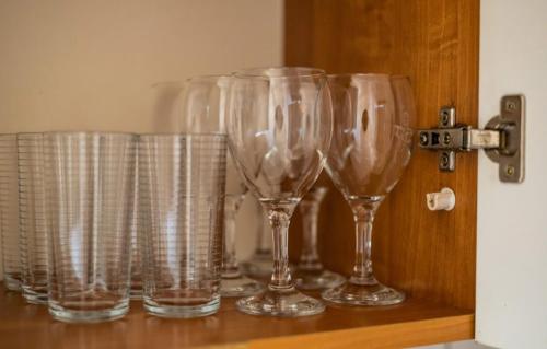 a row of wine glasses sitting on a shelf at Apartament Okrężna in Toruń