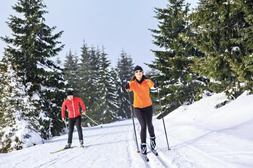 two people cross country skiing on a snow covered slope at Kaisers Tanne - Premium Alles Inklusive Hotel in Breitnau