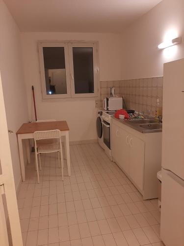 a small kitchen with a table and a sink at Logement T2 tres propre in Cergy