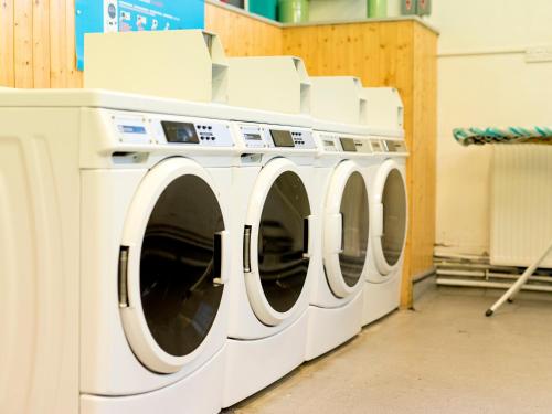 a row of white washing machines in a laundry room at YHA London Thameside in London