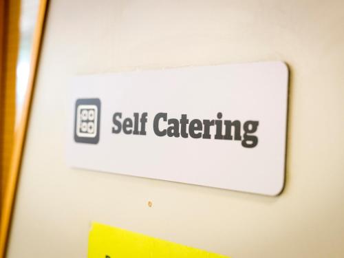 a sign on a wall with the words self catering at YHA London Thameside in London