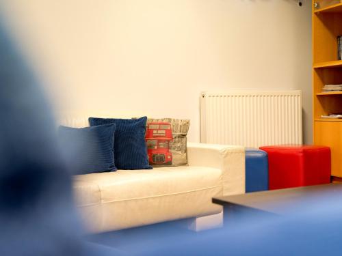 a living room with a white couch with blue pillows at YHA London Thameside in London