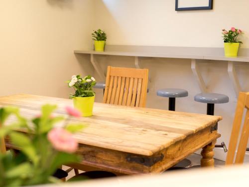 a wooden table with two chairs and a table with flowers at YHA London Thameside in London